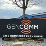 Inside Sales team in front of the GenComm sign