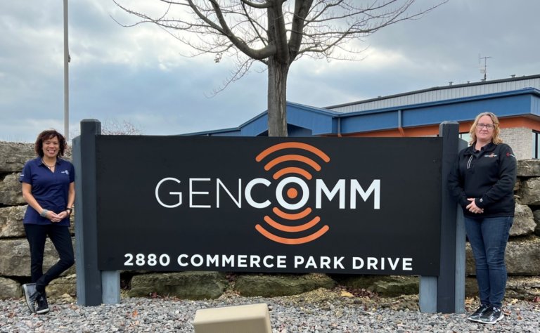 Inside Sales team in front of the GenComm sign
