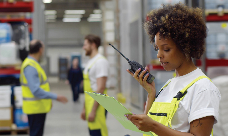 Warehouse employee using a radio for communication