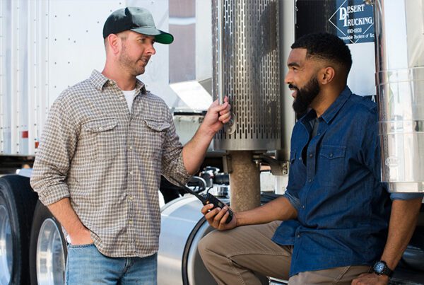 A trucker holding GenComm radio while having a conversation