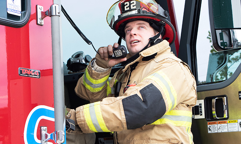 Firefighter using GenComm Radio Accessories for dispatching