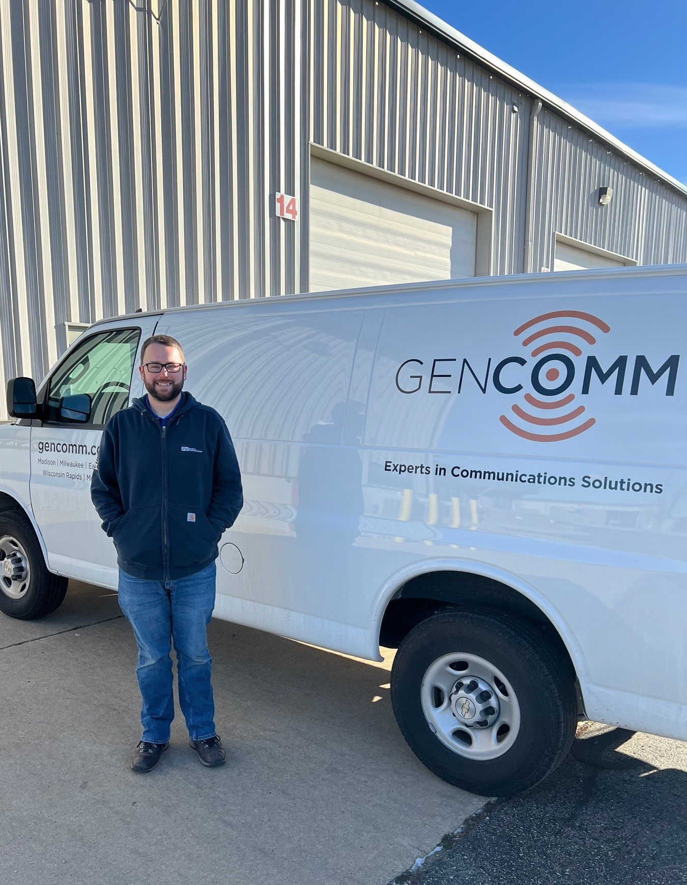 GenComm employee standing in front of one of our GenComm vans