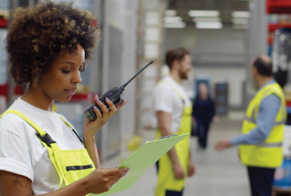 Warehouse employee using a radio for communication - two-way radios have good return on investment