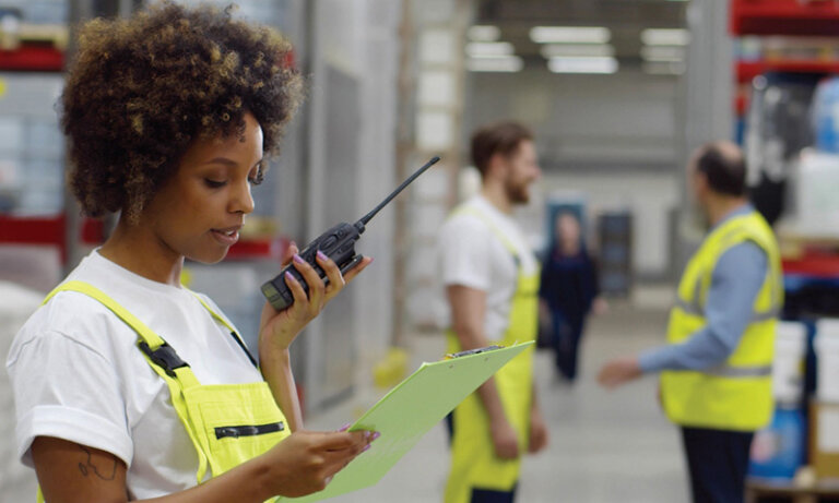 Warehouse employee using a radio for communication - two-way radios have good return on investment