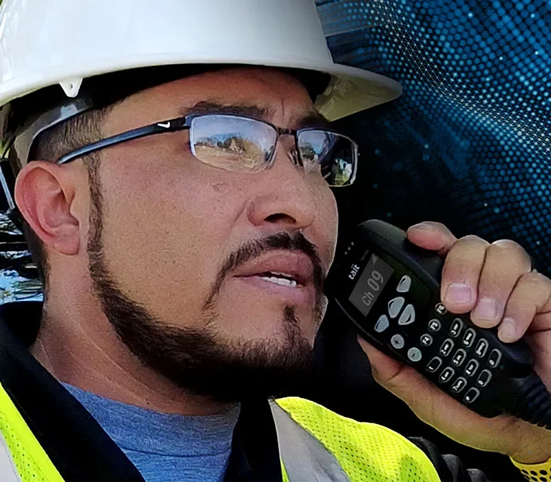 construction worker using Tait radio for safer construction site communication