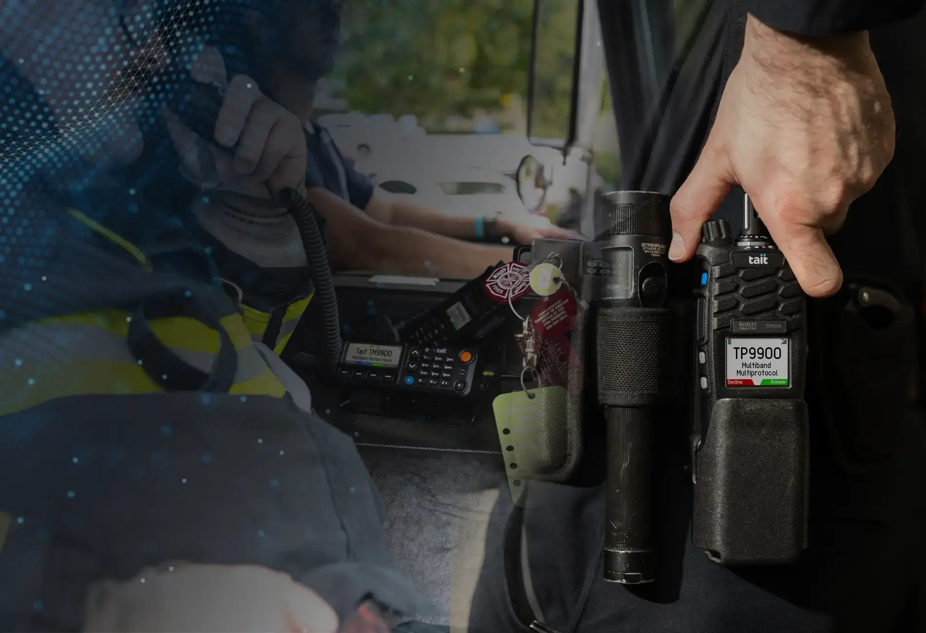 Tait 9900 mobile radio and a first responder holding it while it is on their belt