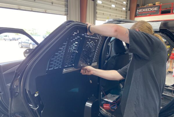installing a shield on a police vehicle for faster response times and better protection and communication