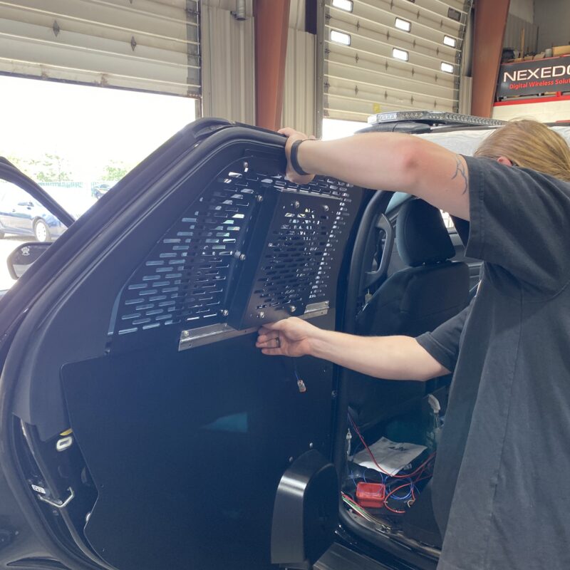 installing a shield on a police vehicle for faster response times and better protection and communication